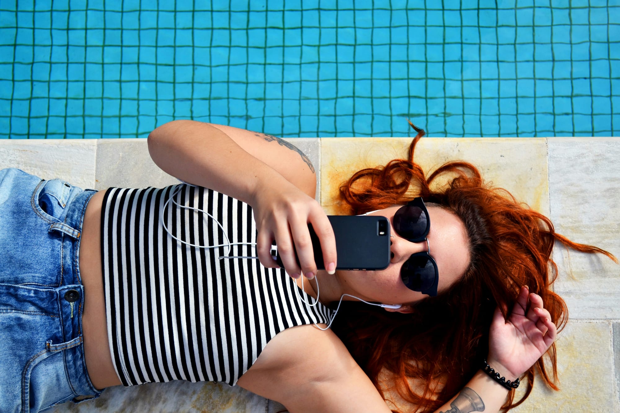 woman laying by swimming pool using tiktok effects