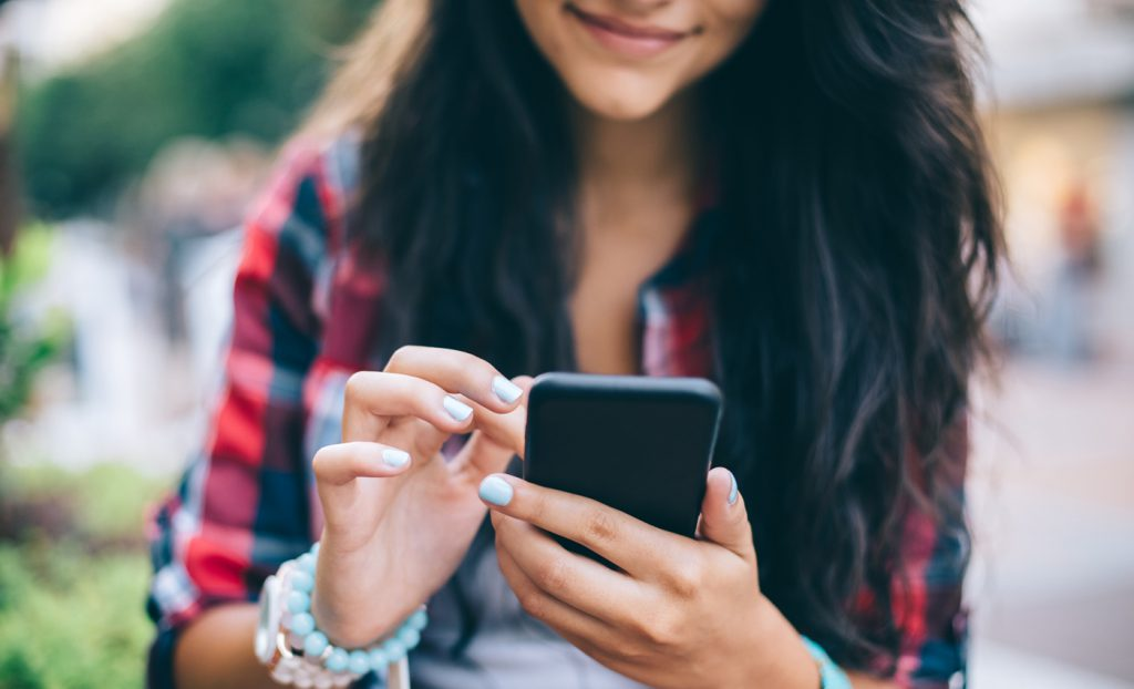 woman using a phone - How to Get More Views on Facebook Reels