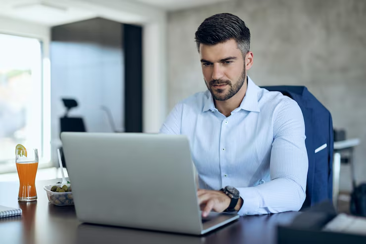 man typing on a laptop - Requirements For YouTube Partner Program