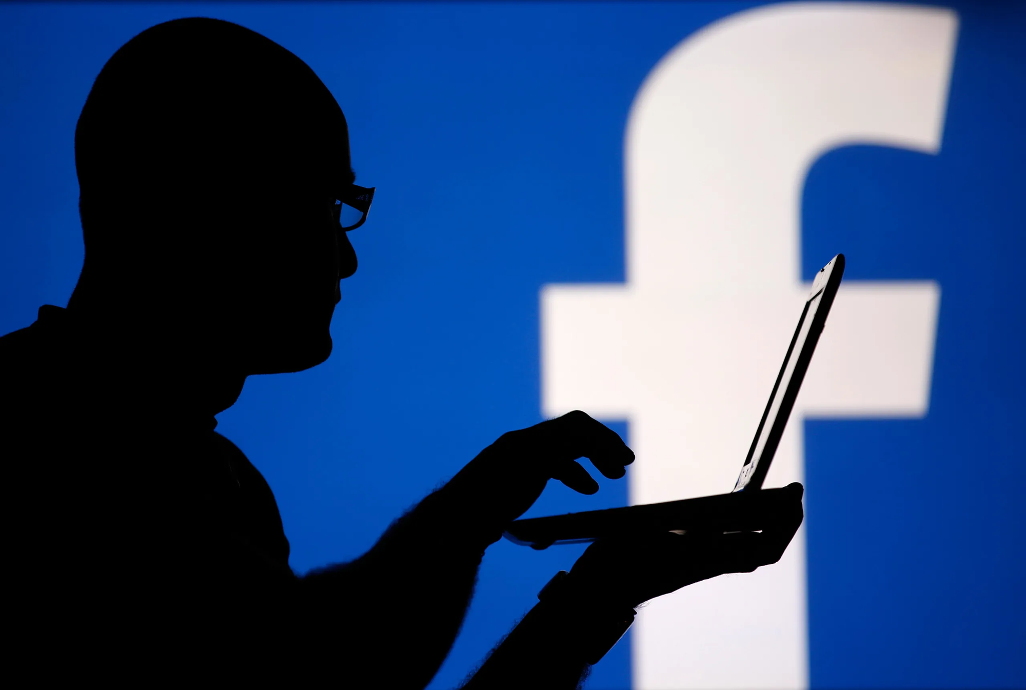 man holding a laptop - How to Get More Views on Facebook for Free